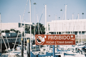 a red sign that is on a pole — Foto por Tomás Brandão na Unsplash
